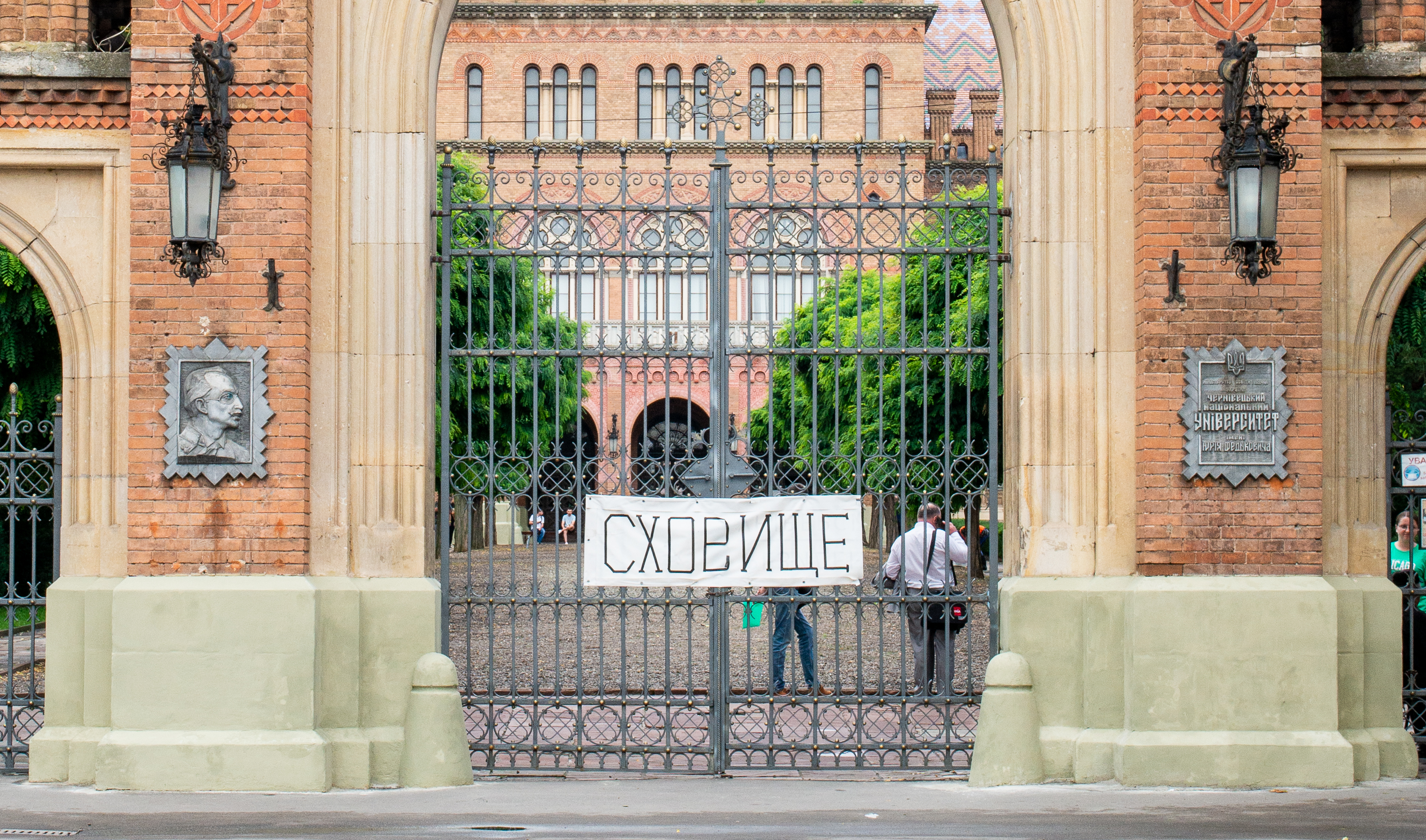 Eingangstor zur Jurij-Fedkowytsch-Universität Czernowitz, auf dem Banner steht ›Schutzraum‹