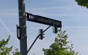 An einer Laterne ist ein Straßenschild mit der Aufschrift "Karl-Liebknecht-Straße" befestigt.