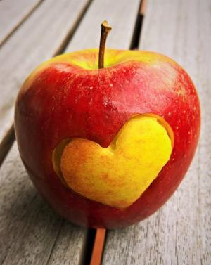 Ein Apfel mit einem Herz-Symbol auf einem Tisch liegend