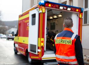 Ein Rettungswagen der Feuerwehr, ein Helfer im Vordergrund