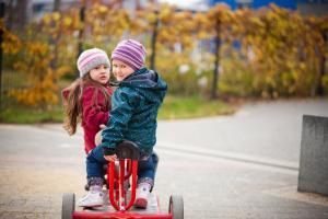 Zwei Kinder auf einem Roller