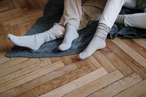 Mehrere Füße in Socken auf einem Holzboden