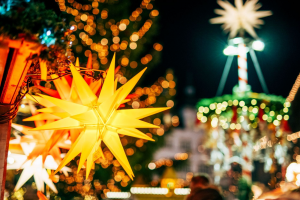 Ein beleuchteter Weihnachtsstern, im Hintergrund Marktgetümmel