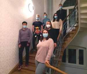 Viele Menschen auf ein Treppe, alle tragen Maske