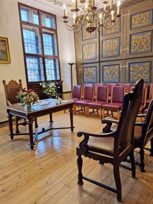 Historisches Zimmer mit Tisch und Stühlen.