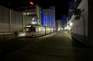 Straßenbahnhaltestelle bei Nacht.
