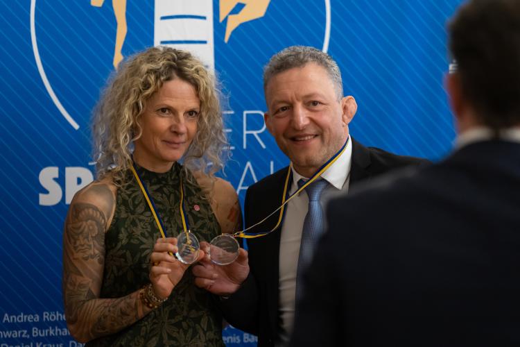 Zwei Menschen halten ihre Medaillen als Auszeichnung zum "Sportler des Jahres" hoch