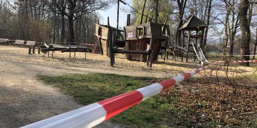 Ein leerer Kinderspielplatz mit Absperrband 
