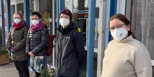 Vier Frauen mit Schutzmaske vor einem Altenheim