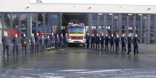 Männer vor einem Feuerwehrwagen