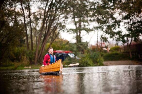 Ein Mann sitzt in einem Kanu auf einem Fluss