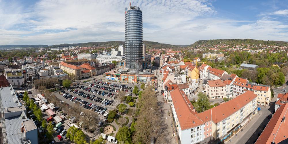 Ein großer Parkplatz mit einem modernen Turm dahinter