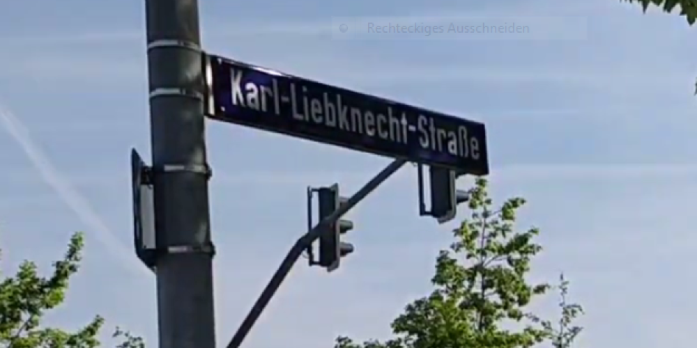 An einer Laterne ist ein Straßenschild mit der Aufschrift "Karl-Liebknecht-Straße" befestigt.