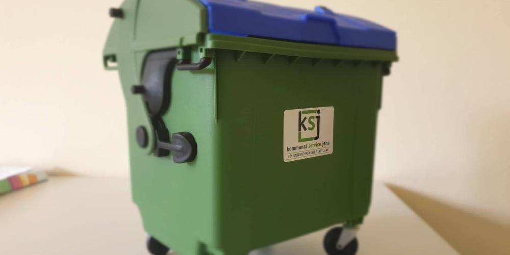 Ein grüner Miniatur-Müllcontainer von KSJ