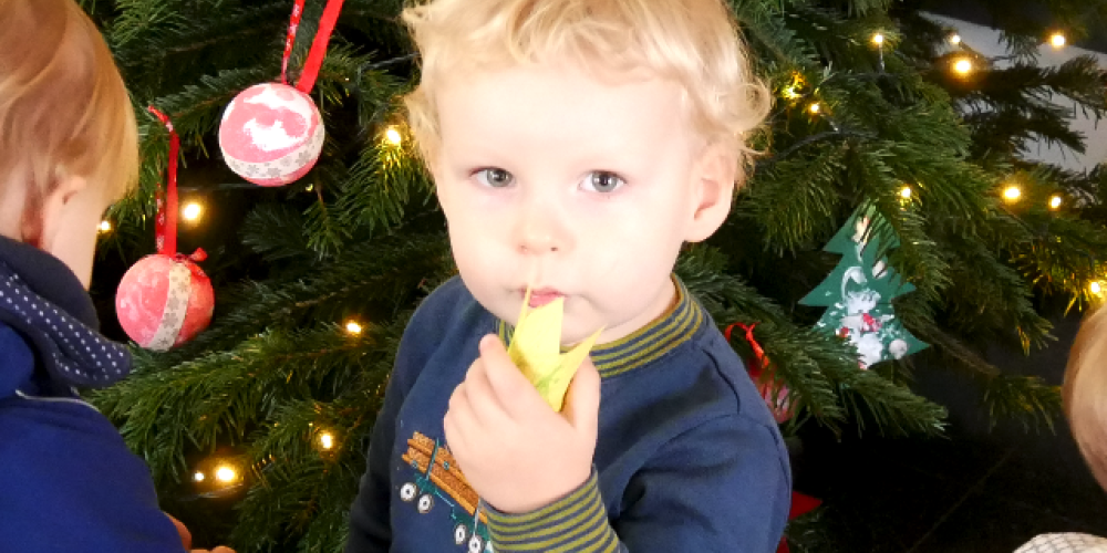 Ein Kind vor einem Weihnachtsbaum