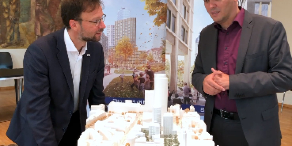 Zwei Personen diskutieren über ein Stadtmodell gebeugt