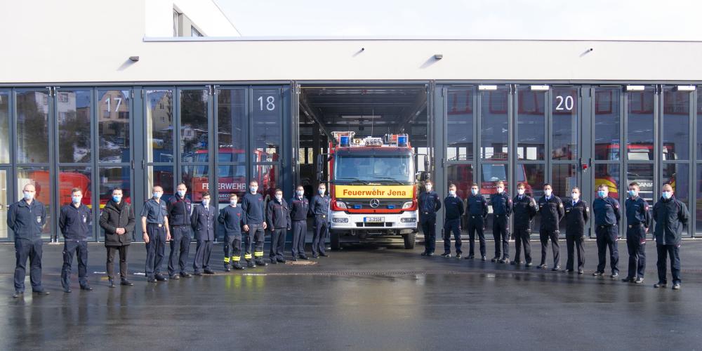 Viele Männer in Uniform vor einem Feuerwehrwagen