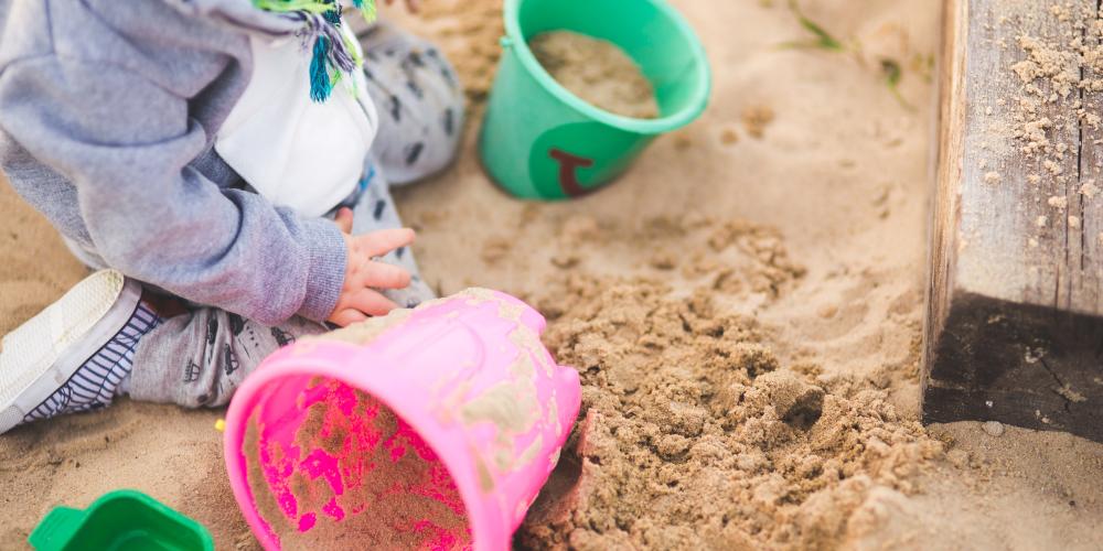 Ein Kind spielt im Sandkasten