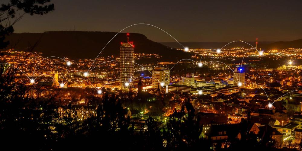 Skyline von Jena bei Nacht, Lichtbögen verbinden einzelne Teile der Stadt