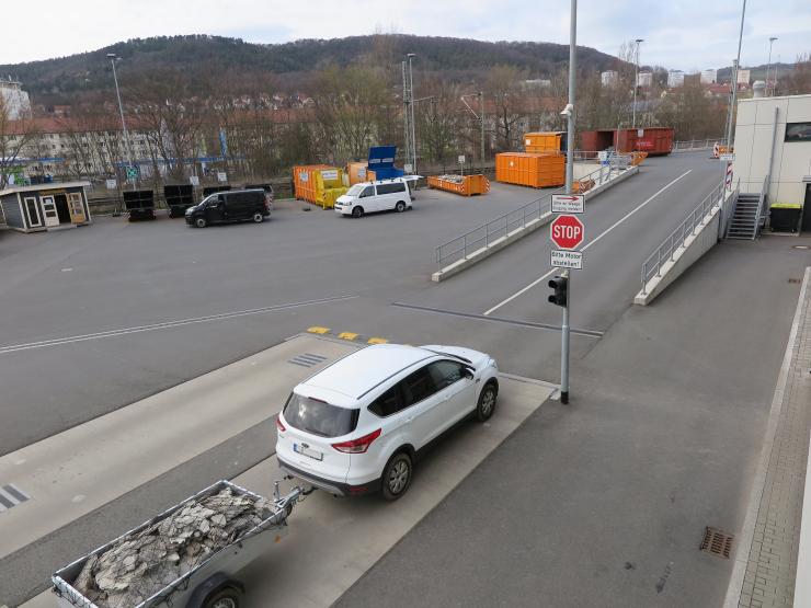 Ein Auto auf einem großen Hof mit vielen Containern