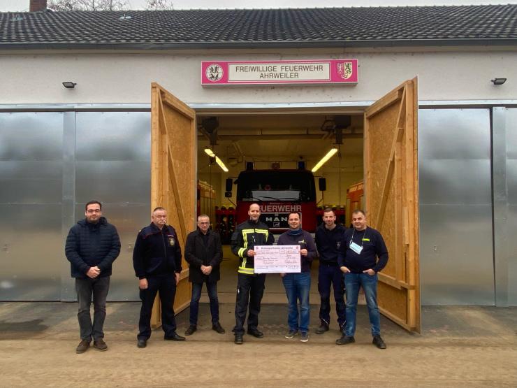 Feuerwehrmänner halten einen Scheck 