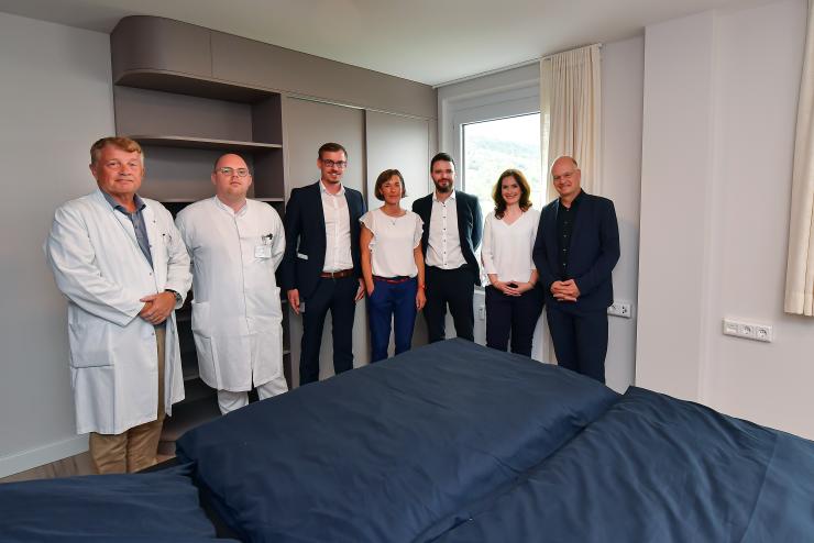 Gruppenbild aller an den Gesundheitsapartments Beteiligten: Klinikdirektor Prof. Dr. Utz Settmacher vom Universitätsklinikum Jena (UKJ), Felix Donndorf, leitender Oberarzt am UKJ, Projektleitung Mandy Steinbrück von den Stadtwerken Energie, Projektleiter Stefan Albert vom UKJ, Benjamin Koppe, Dezernent für Finanzen, Sicherheit und Bürgerservice, Dorothea Prell, Digitalisierungsbeauftragte der Stadt Jena sowie Stadtwerke-Geschäftsführer Tobias Wolfrum.