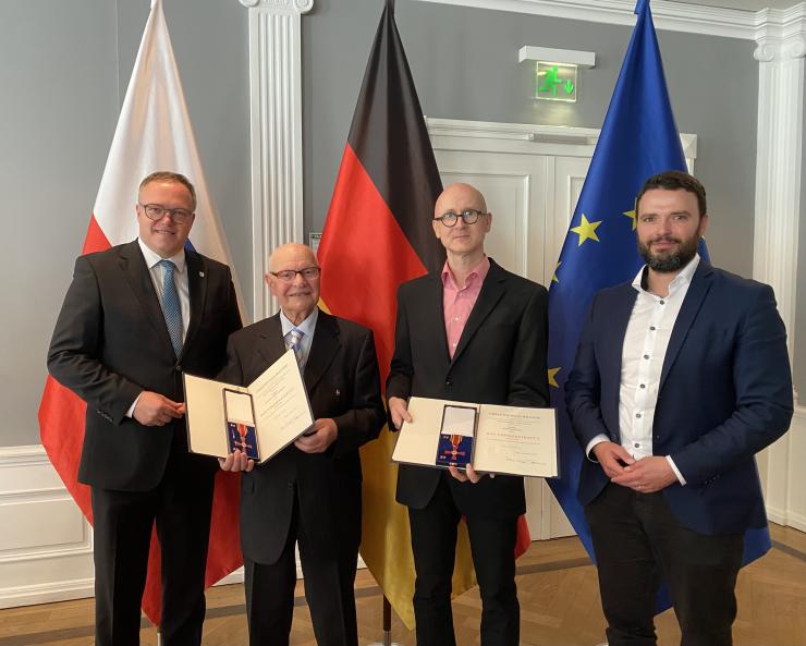 Vier Männer schauen in die Kamera.