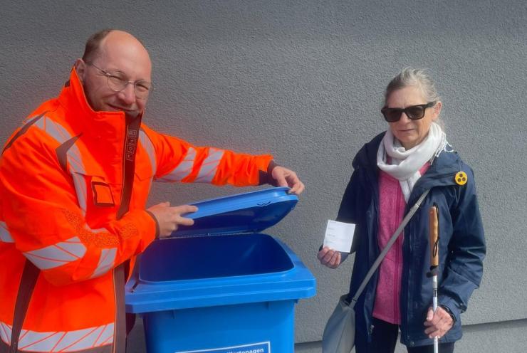 Martin Steglitz und Beatrix Adloff haben den ersten Aufkleber auf einer blauen Tonne angebracht.