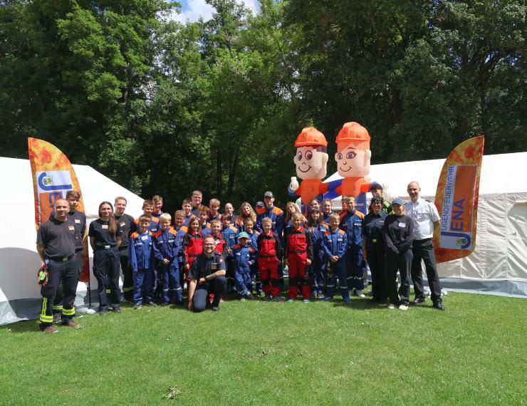 Gruppe von Erwachsenen und Kindern lächelt in die Kamera.
