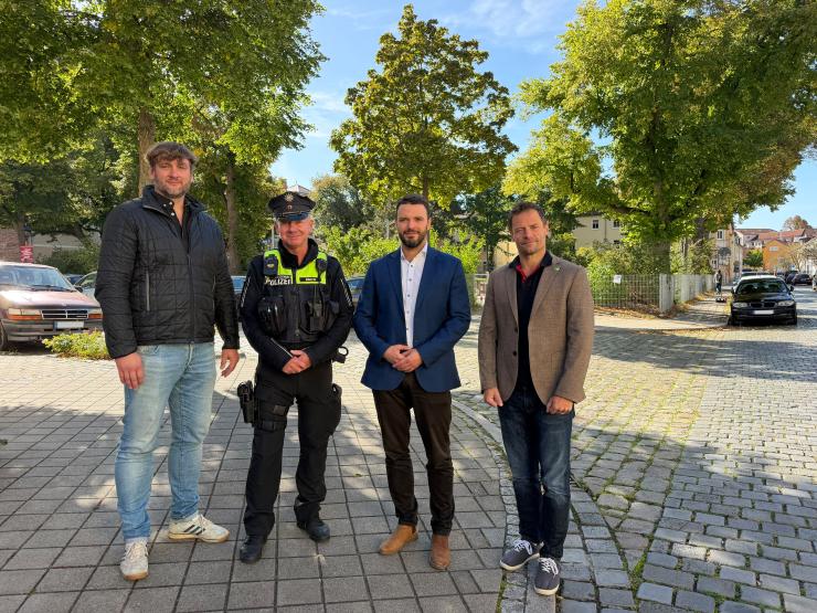 Vier Männer lächeln in die Kamera.