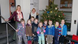 weihnachtsbaum im Vordergrund eine Druppe Kinder von der Kita