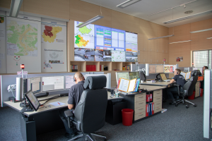 Drei Männer bei der Arbeit in der Leitstelle Jena. Sie sitzen vor Rechnern und mehreren Bildschirmen.