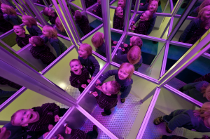 Eine Kindergruppe spiegelt sich in vielen Spiegeln wider