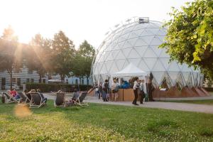 In einem Park steht ein kuppelförmiger Pavillion. 