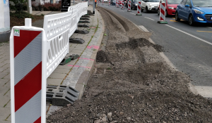 Der Abbeigestreifen einer mehrspurigen Straße ist wegen Bauarbeiten abgesperrt und der Asphalt aufgerissen. 