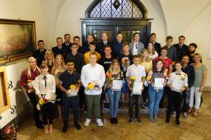 Die neue Auszubis der Stadtverwaltung Jena stehen auf einer Treppe im historischen Rathaus.