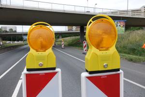 Zwei Warnbalken stehen auf der gesperrten Stadtrodaer Straße.