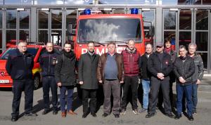 Eine Gruppe von Menschen vor einem Feuerwehrwagen