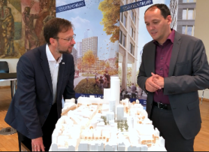 Zwei Personen diskutieren über ein Stadtmodell gebeugt