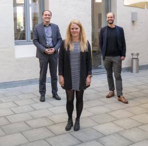 Drei Personen schauen in die Kamera