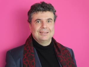 Ein Mann mit Künstlerschal schaut in die Kamera