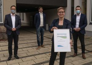 Vier Menschen schauen in die Kamera