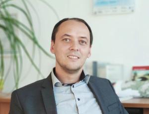 Ein Mann am Schreibtisch schaut in die Kamera