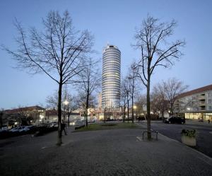 Der Jentower im Vordergrund zwei Bäume ohne Blätter