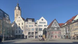 Eine Platzmit Denkmal, im Hintergrund Häuser