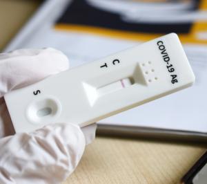 Eine Hand hält einen Schnelltestchip