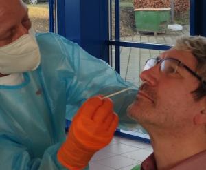 Ein Mann führt ein Stäbchen in die Nase seines Gegenübers