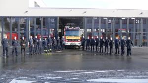 Männer vor einem Feuerwehrwagen