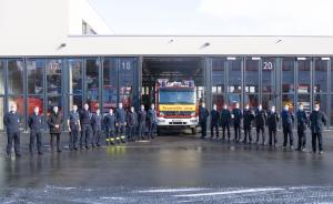 Viele Männer in Uniform vor einem Feuerwehrwagen