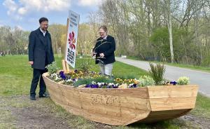 Zwei Menschen hinter einem Blumenbeet in Form eines Bootes